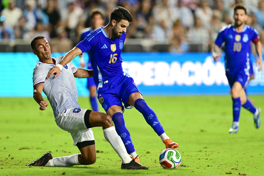 El defensor puertorriqueño Giovanni Calderón (i) marca a presión al delantero de la selección argentina José Manuel 'el Flaco' López, quien debutó durante el partido amistoso jugado este martes en el Chase Stadium, de Fort Lauderdale, y que la Albiceleste ganó por 0-6. EFE/ Giorgio Viera